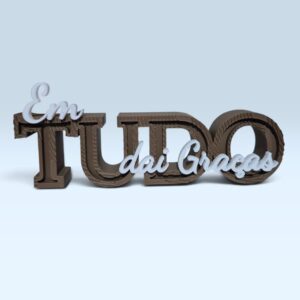 Letreiro 3D Em Tudo Dai Graças em marrom com detalhes brancos sobre fundo azul-claro